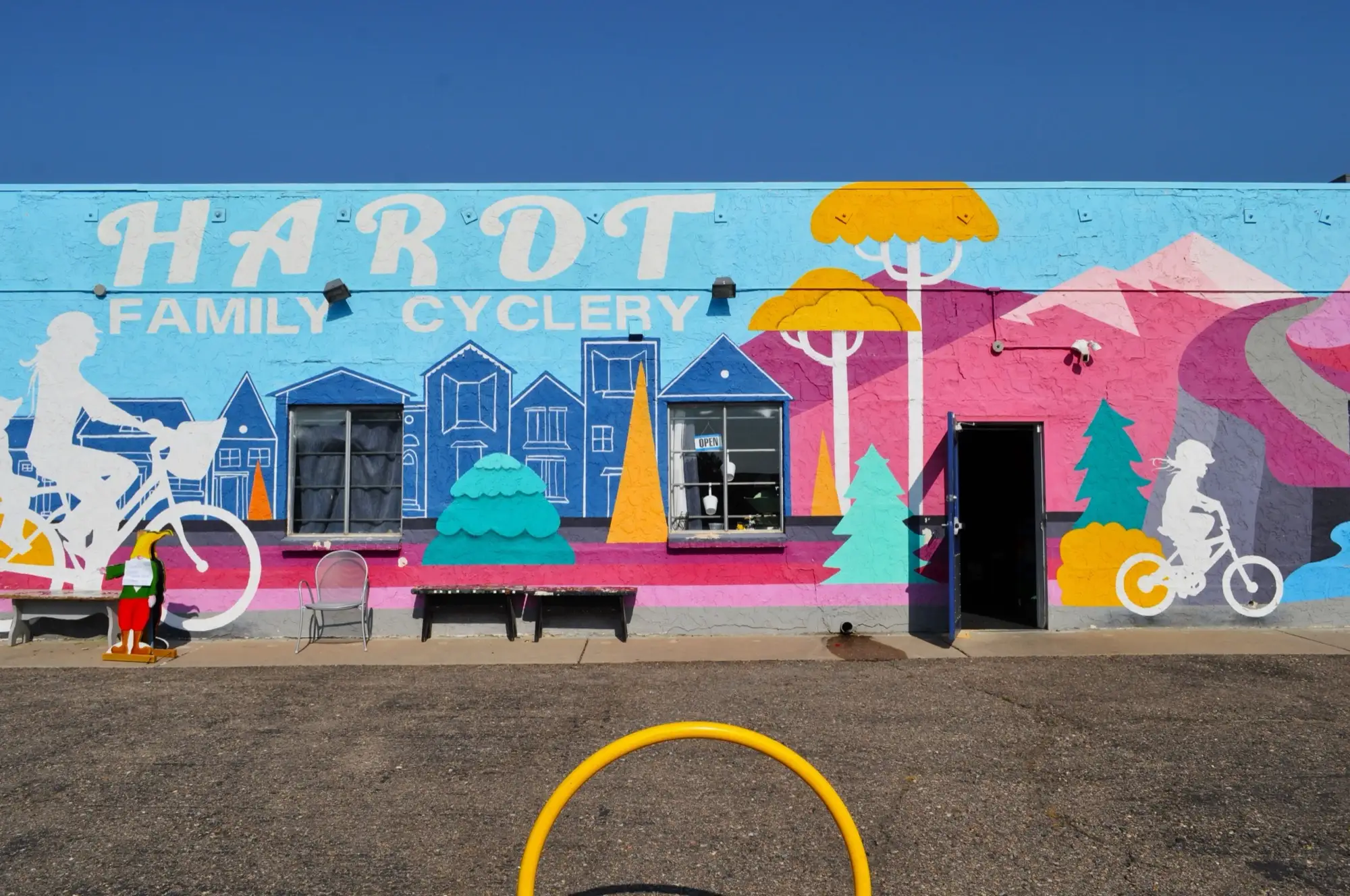The Hardt Family Cyclery building, covered in a bright mural of families riding bikes